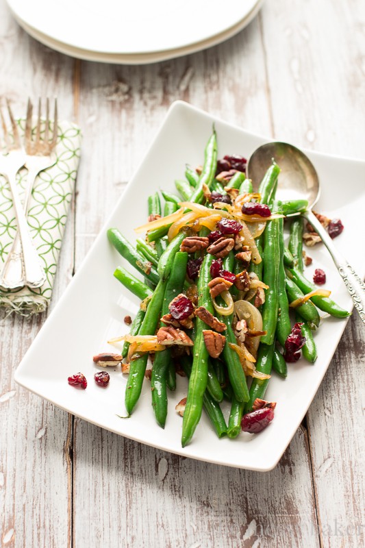 This easy side dish is perfect for Thanksgiving. Crisp green beans get tossed with caramelized onions, toasted pecans, and dried cranberries. | www.themessybakerblog.com